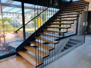 MILD STEEL POWDER COATED FLOATING STAIRCASE WITH OAK WOOD TREADS & 16mm CLEAR GLASS BALUSTRADE.